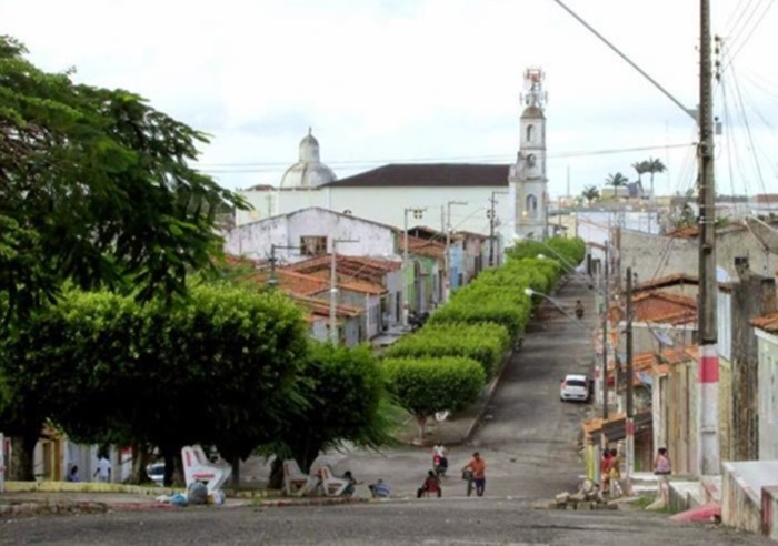 Rua arborizada do centro de Aquidabã com a Igreja Matriz ao fundo