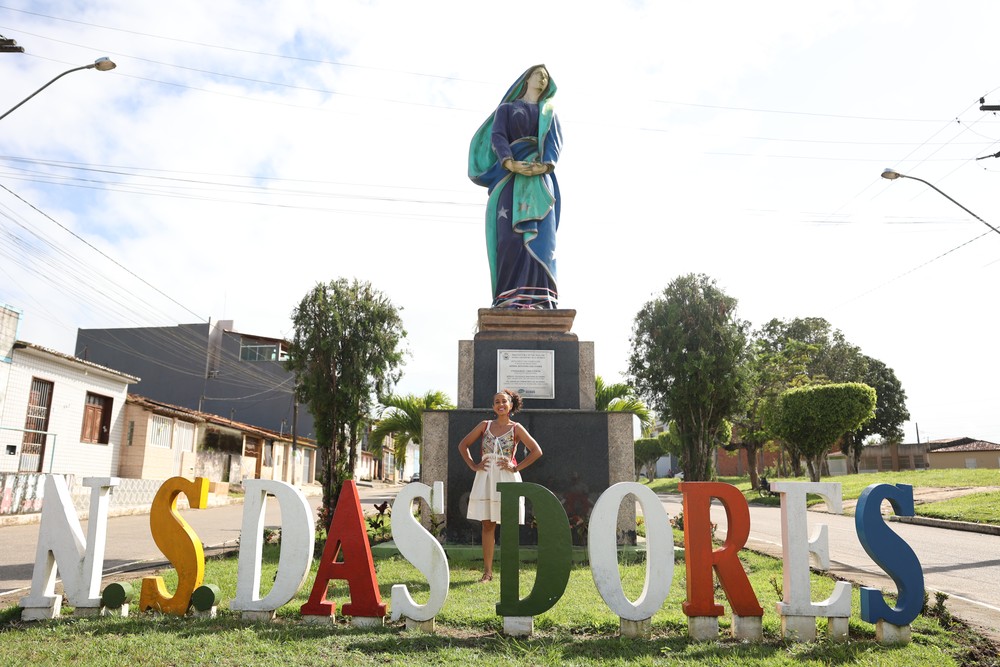 Monumento de Nossa Senhora das Dores com o letreiro colorido da cidade